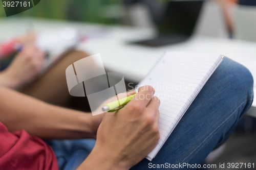 Image of male student taking notes in classroom