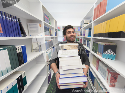 Image of Student holding lot of books in school library