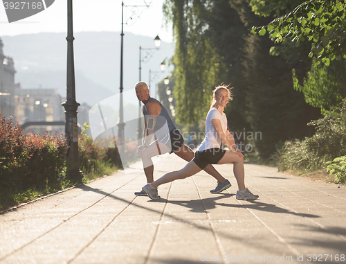 Image of couple warming up and stretching before jogging