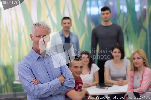 Image of portrait of  teacher with students group in background