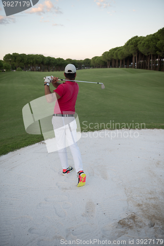 Image of golfer hitting a sand bunker shot on sunset