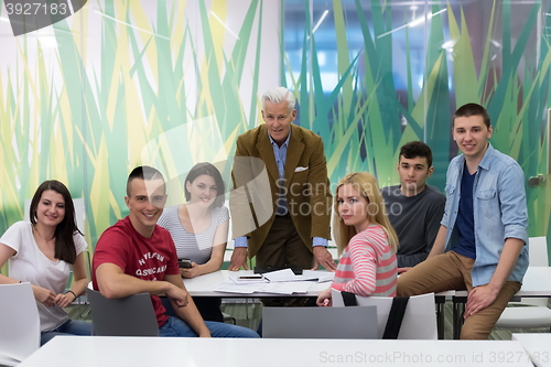 Image of portrait of  teacher with students group in background