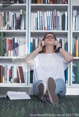 Image of female student study in library, using tablet and searching for 