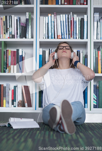 Image of female student study in library, using tablet and searching for 