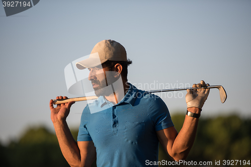 Image of golfer  portrait at golf course on sunset