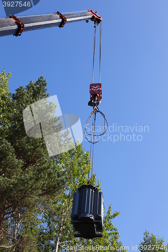 Image of Crane hook lifts up the power transformer