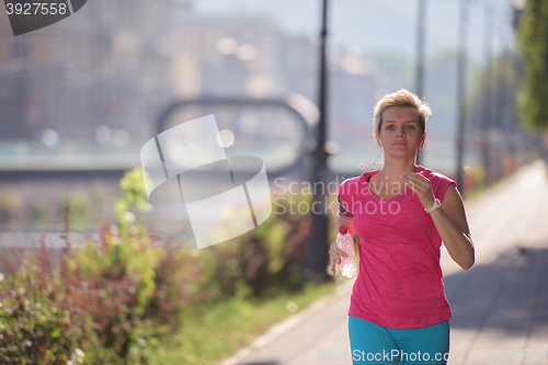Image of sporty woman running  on sidewalk