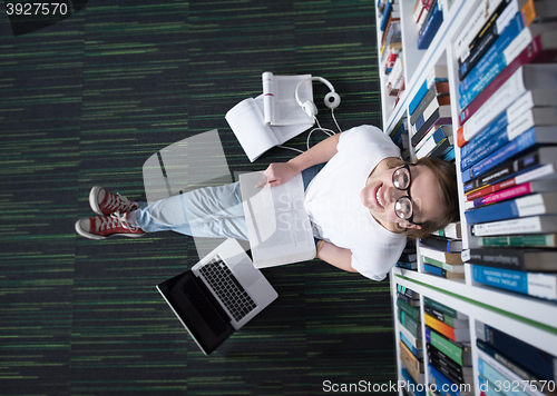 Image of female student study in library, using tablet and searching for 