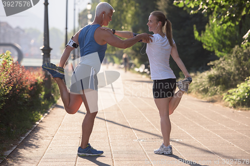 Image of couple warming up and stretching before jogging