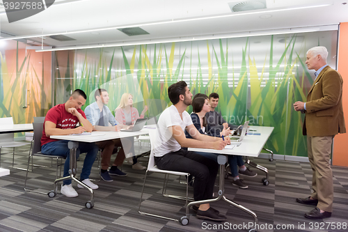 Image of teacher with a group of students in classroom