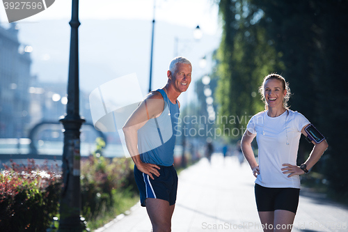 Image of jogging couple planning running route  and setting music