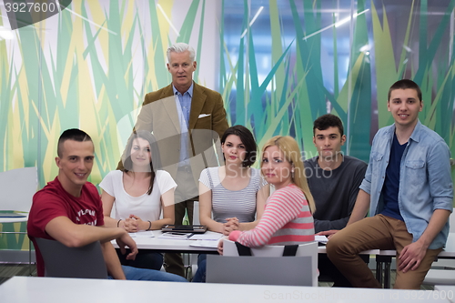 Image of portrait of  teacher with students group in background