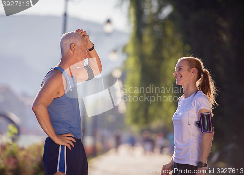 Image of jogging couple planning running route  and setting music