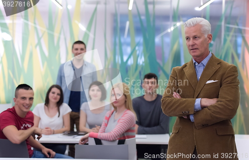 Image of portrait of  teacher with students group in background