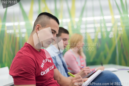 Image of male student taking notes in classroom