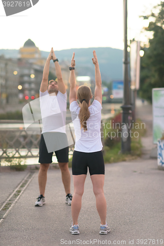 Image of couple warming up before jogging