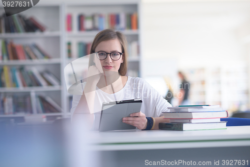 Image of female student study in school library, using tablet