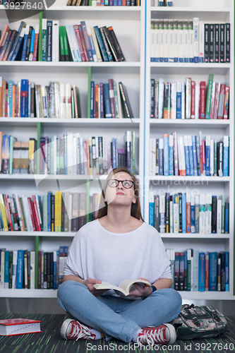 Image of famale student reading book in library