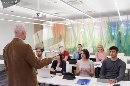 Image of teacher with a group of students in classroom