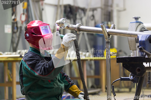 Image of Industrial worker welding in metal factory.