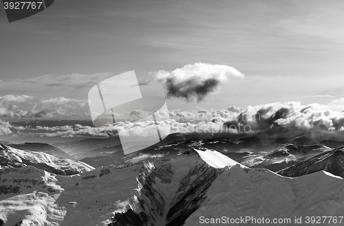 Image of Black and white winter mountains at evening and sunlight clouds