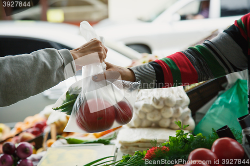 Image of woman buys vegetables at a market