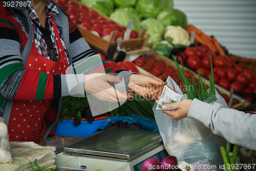 Image of woman buys vegetables at a market