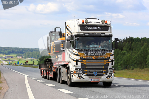 Image of Customized Scania R560 Semi Hauls Excavator along Freeway