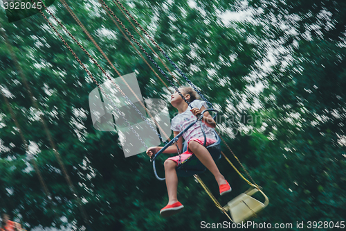 Image of girl riding on chained carousel