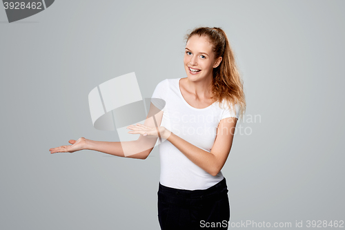 Image of Smiling woman showing open hand palm with copy space