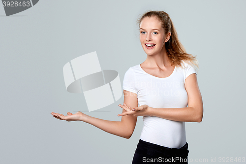 Image of Smiling woman showing open hand palm with copy space