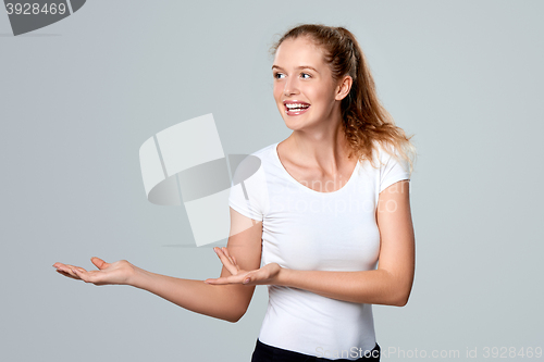 Image of Smiling woman showing open hand palm with copy space