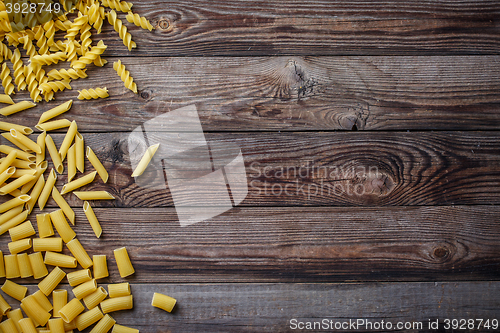 Image of Mixed dried pasta selection on wooden background.