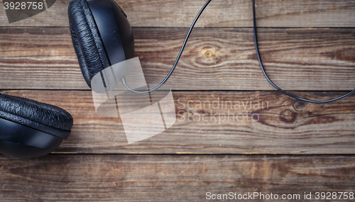 Image of Headphones over wooden table.