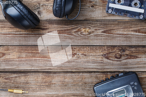 Image of Cassette tapes, cassette player and headphones over wooden table. top view.