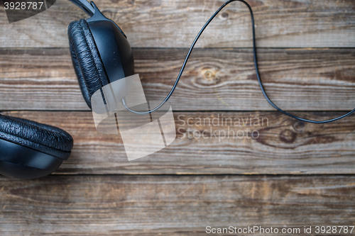 Image of Headphones over wooden table.
