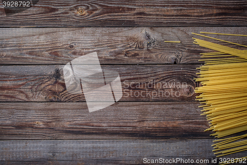 Image of Yellow long spaghetti on black background. Raw spaghetti.
