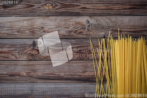 Image of Yellow long spaghetti on black background. Raw spaghetti.