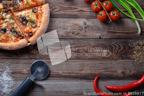 Image of Tasty pizza with ingridients on a wooden board.