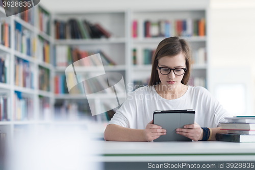 Image of female student study in school library, using tablet