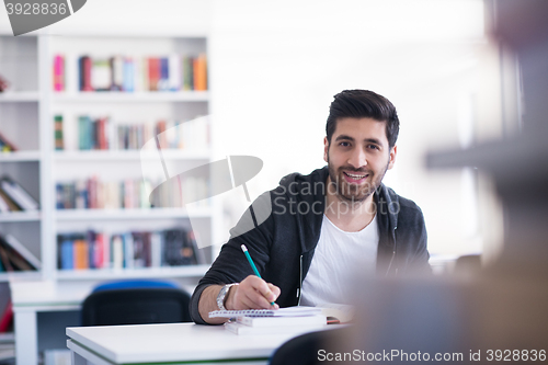 Image of student in school library using laptop for research