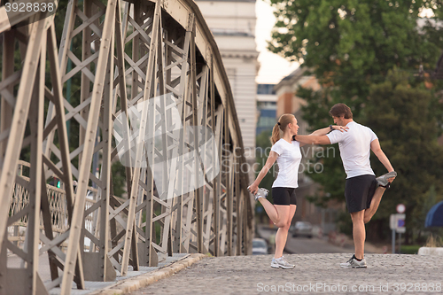 Image of couple warming up and stretching before jogging