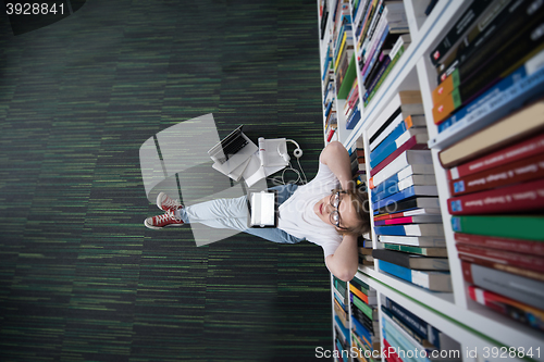 Image of female student study in library, using tablet and searching for 