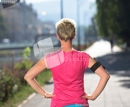 Image of jogging woman setting phone before jogging