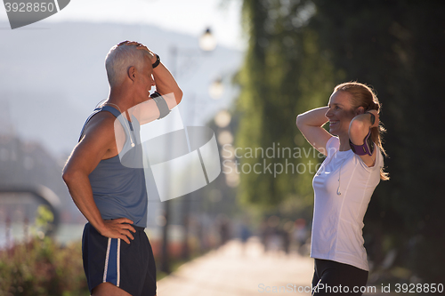 Image of jogging couple planning running route  and setting music