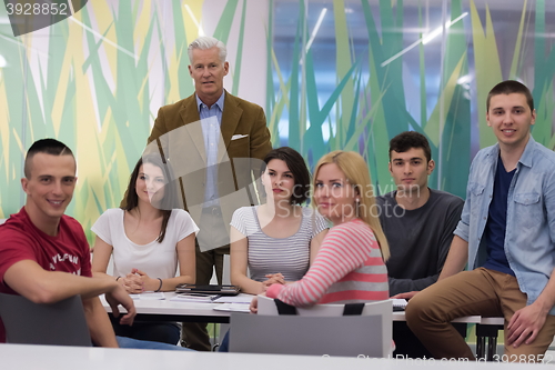 Image of portrait of  teacher with students group in background