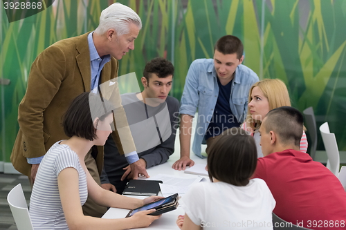 Image of teacher with a group of students in classroom