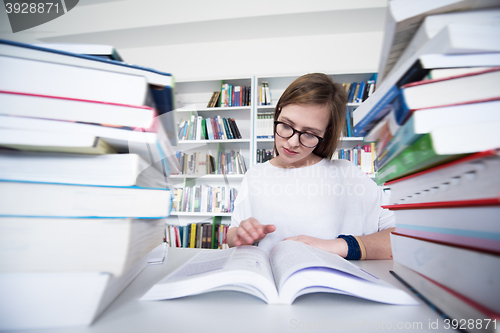 Image of female student study in library, using tablet and searching for 