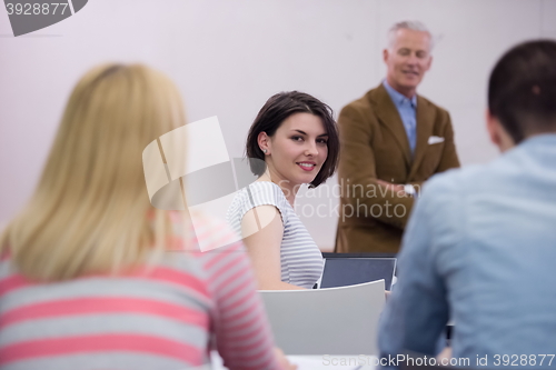 Image of teacher with a group of hi school students in classroom