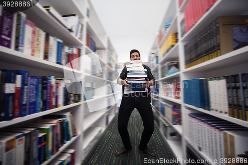 Image of Student holding lot of books in school library